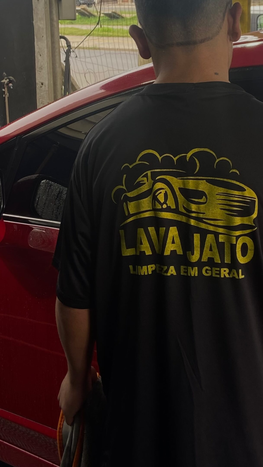 Equipe da CM Estética Automotiva finalizando um carro vermelho